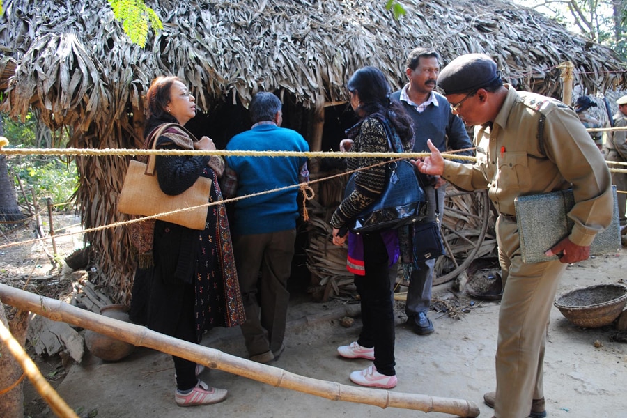 Policemen and forensic experts inspect the site where a woman was gang raped