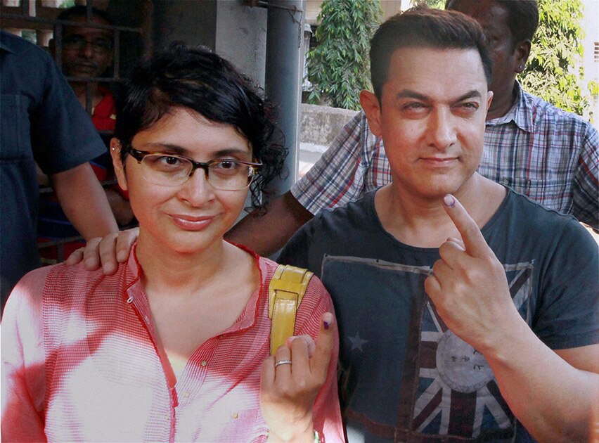Bollywood actor Amir Khan with his wife Kiran Rao dislpay their inked finger after casting their vote in Mumbai.