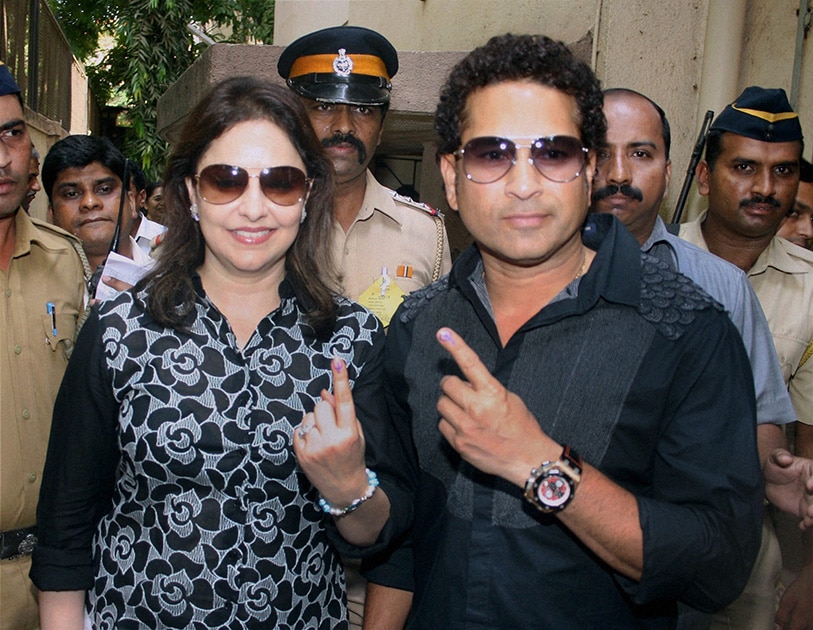 Master Blaster Sachin Tendulkar with wife Anjali Tendulkar display their inked finger after casting their vote in the Lok Sabha Elections 2014 in Mumbai.