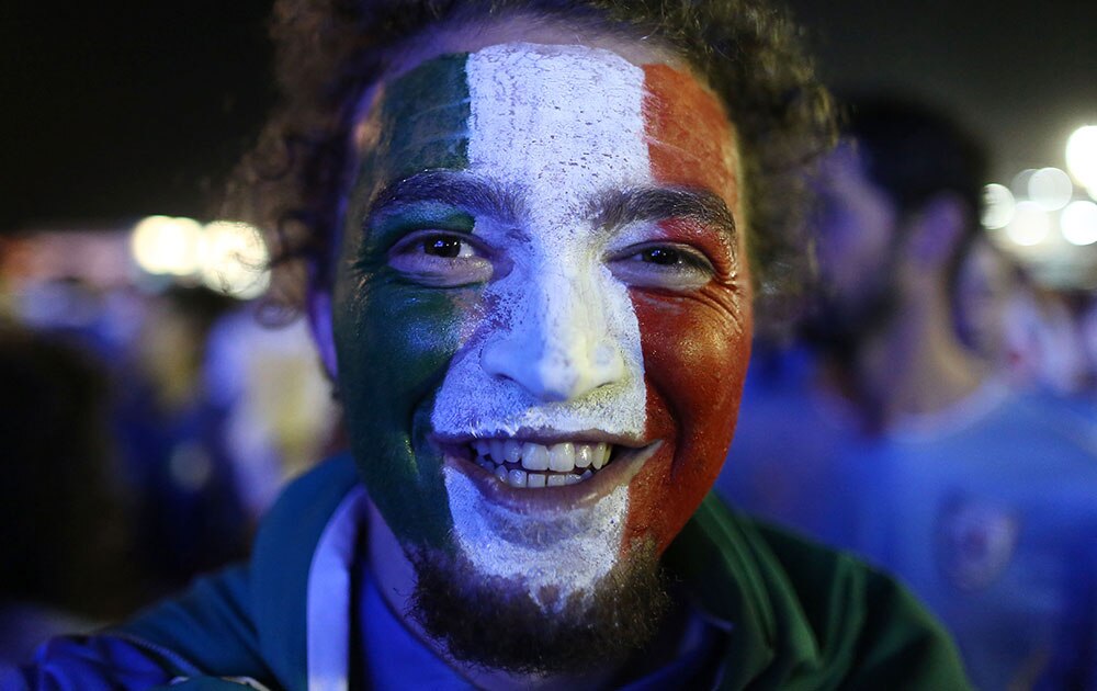 A Italian soccer fan poses for a photo after his team's victory during a live broadcast of the World Cup match between England and Italy, inside the FIFA Fan Fest area on Copacabana beach, in Rio de Janeiro, Brazil.