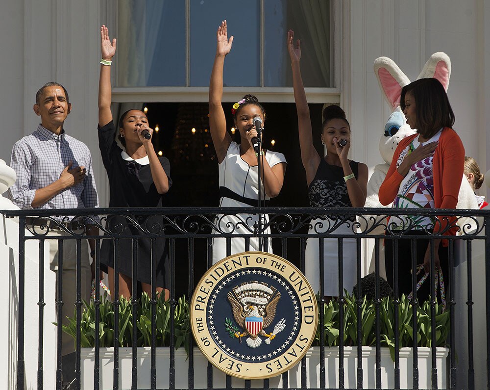 President Barack Obama and first lady Michelle Obama listen to 'iD4GIRLS' perform the National Anthem during the White House Easter Egg Roll on the South Lawn of White House in Washington.
