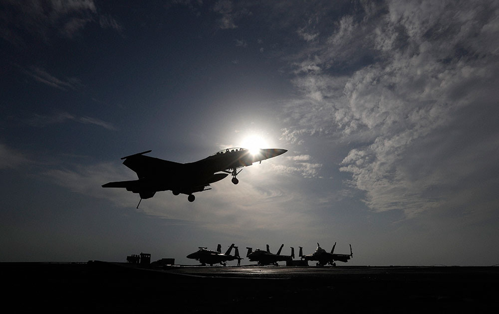 A U.S. Navy fighter jet lands on the deck of the U.S.S. Theodore Roosevelt aircraft carrier