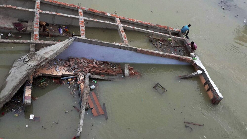 A building collapses in flood water at Chapra