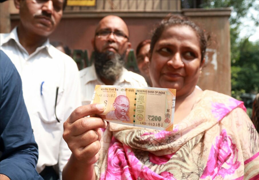 A woman shows the new Rs 200 currency note