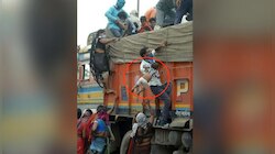 এক হাতে দুধের শিশুদের তুলে দেওয়া হচ্ছে ট্রাকে, এভাবে বাড়ির পথে পরিযায়ী শ্রমিকরা
