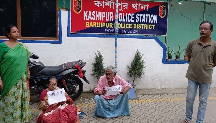 &#039;বিচার চাই, শাস্তি চাই&#039;, থানার সামনে প্ল্যাকার্ড হাতে ধরনায় বৃদ্ধ দম্পতি